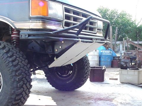 1988 Ford Bronco - Close-up of a truck's front end, focusing on the bumper and off-road tire.