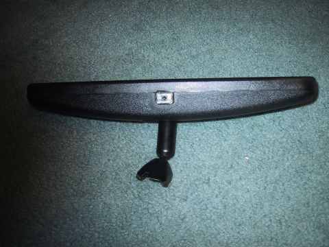 1994 Ford Bronco - A black rear view mirror with a broken mounting bracket is shown against a carpeted surface.
