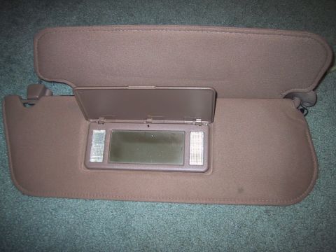 1994 Ford Bronco - The photo shows two car sun visors, one of which is open to reveal a vanity mirror with illuminated sides.