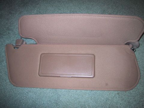 1994 Ford Bronco - A tan sun visor with a vanity mirror cover is shown against a teal carpeted background.