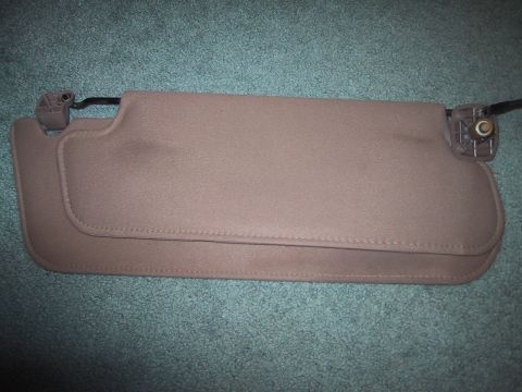 1994 Ford Bronco - Pair of tan sun visors, likely from an older vehicle, shown against a carpeted background.