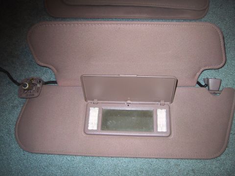 1994 Ford Bronco - Two tan car sun visors are shown, with one open to reveal a lighted mirror.