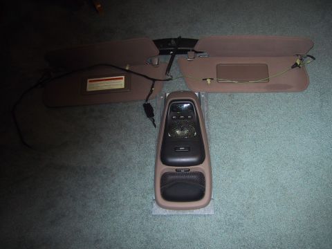 1994 Ford Bronco - This photo shows a disassembled overhead console and sun visors, likely removed from a vehicle for repair or replacement.