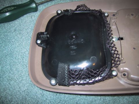 1994 Ford Bronco - A disassembled vehicle interior part, possibly from an overhead console, is shown with a screwdriver nearby.