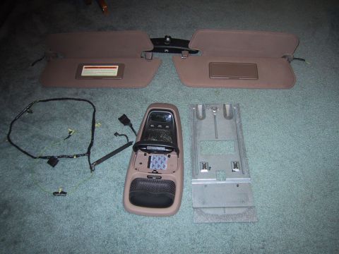 1994 Ford Bronco - Vehicle interior parts including sun visors and an overhead console are displayed on a carpeted surface.