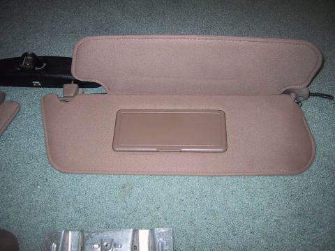 1994 Ford Bronco - Interior parts including sun visors and overhead console components are shown laid out on a carpeted surface.