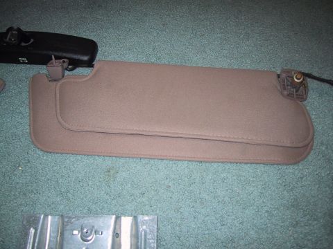 1994 Ford Bronco - Tan sun visors and black rearview mirror removed from a vehicle.