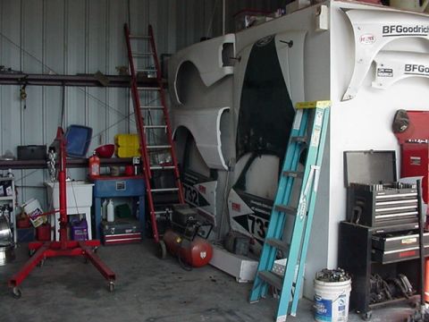 1988 Ford Bronco - A workshop scene with various car parts and equipment, including an air compressor and ladders.