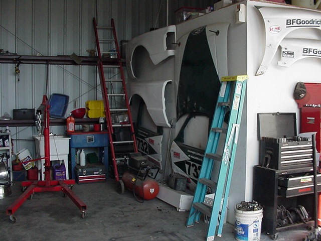White fiberglass race truck body panels with BFGoodrich and 732 leaning on a shop wall