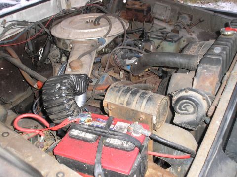 1978 Ford Bronco - Close-up view of a vehicle's engine bay, showing the battery, radiator, and various engine components.