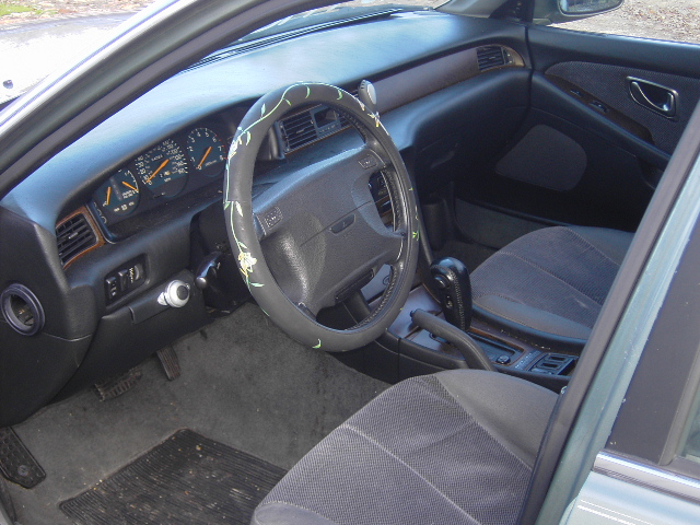 Sedan interior with steering wheel, gauges, console shifter and gray cloth seats