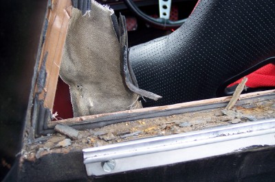 1972 Ford Ranchero - Close-up of a damaged car interior showing a torn window seal and upholstery.