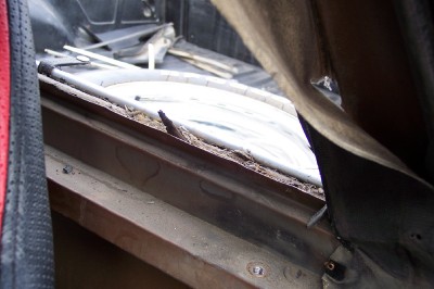 1972 Ford Ranchero - The interior of a vehicle bed is visible, filled with debris and showing a partial view of a window.
