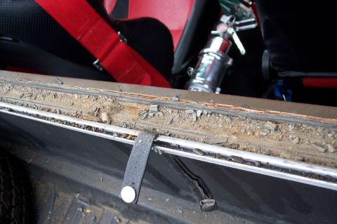1972 Ford Ranchero - Interior view of a vehicle, racing seats and a fire extinguisher, with debris on the window seal.