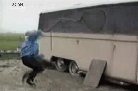 1995 Ford Bronco - A person is seen kicking the side of a trailer, which appears to be damaged.