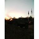 1993 Ford Bronco - A 1993 Ford Bronco is seen in profile against a sunset sky, with two flags visible in the background.