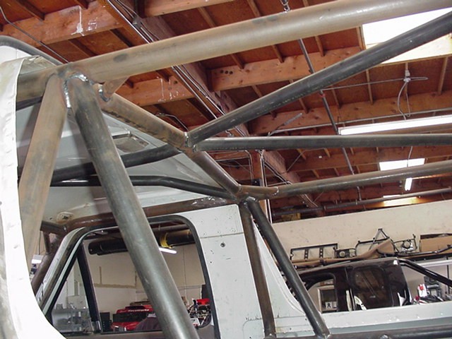 Welded tubular roll cage bars inside a vehicle in a workshop