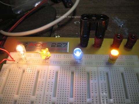 2003 Ford Crown Victoria - A breadboard displays various LEDs and incandescent bulbs illuminated, with text indicating '194 bulb is the brightest'.