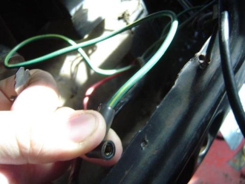 1979 Ford Bronco - Close-up of a hand holding a wiring harness connector with green and yellow wires.