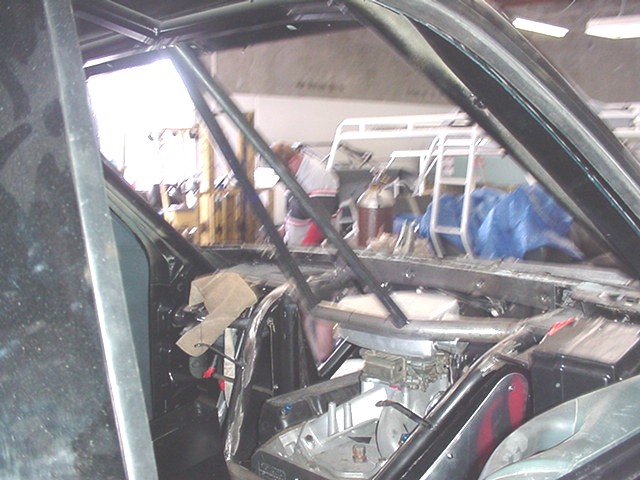Vehicle interior with roll cage and exposed engine in a garage