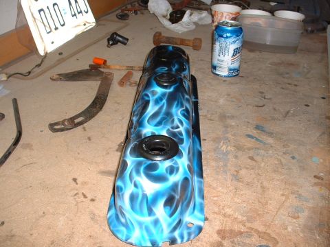 1978 Ford Mustang II - A custom painted valve cover with a blue flame design sits on a garage floor next to a license plate and a beer can.