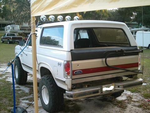 1986 Ford Bronco - Rear view of a lifted 1986 Ford Bronco with off-road tires and roof-mounted lights.