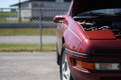 1991 Ford Probe - The front-right of a red 1991 Ford Probe is visible with the hood open.