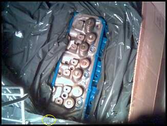 1979 Ford Bronco - Engine cylinder head part, likely for a Ford vehicle, covered in plastic.