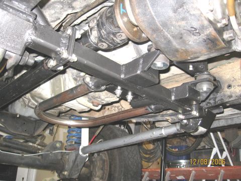 1994 Ford Bronco - Custom crossmember installation on a vehicle's undercarriage, showing drivetrain and suspension parts.