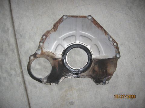 1994 Ford Bronco - This is an engine timing cover with a seal, photographed on October 27, 2006. It shows signs of rust and oil residue.
