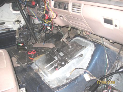 1994 Ford Bronco - The interior of a vehicle shows extensive wiring and two gear shifters, suggesting modifications.