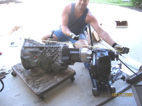 1994 Ford Bronco - A man measures a transmission and transfer case assembly, possibly for a vehicle modification.