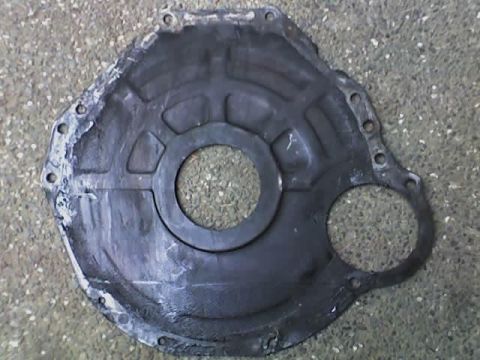1994 Ford Bronco - A transmission bell housing part is shown lying on a concrete surface.