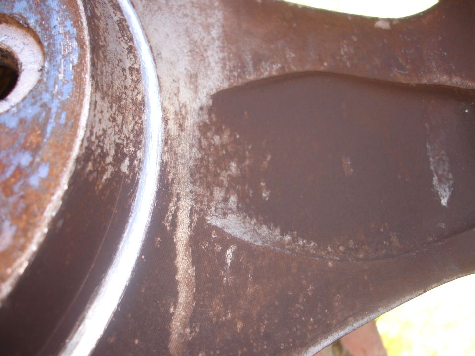 Close-up of a rusty brake rotor with some white paint on the edge