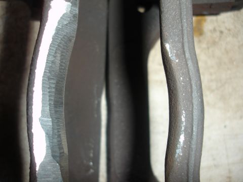 1993 Ford Taurus - Close-up view of a worn brake caliper, showing significant scoring on the metal surface.