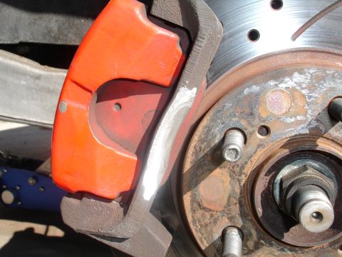 1993 Ford Taurus - Close-up of a red brake caliper and rotor assembly, likely a performance upgrade.