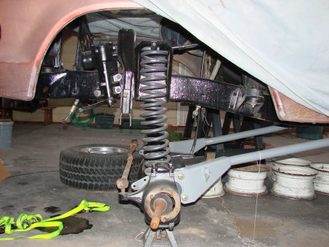 1979 Ford Bronco - Close-up view of the front suspension and brake system, likely undergoing maintenance or upgrade.