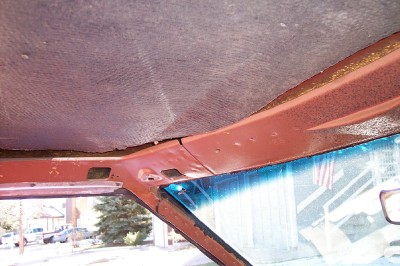1972 Ford Ranchero - The interior headliner and surrounding metal trim of a vehicle show signs of age and wear.