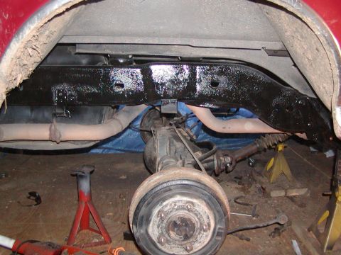 1991 Ford Bronco - Vehicle's rear axle and frame components are visible, supported by jack stands during maintenance.