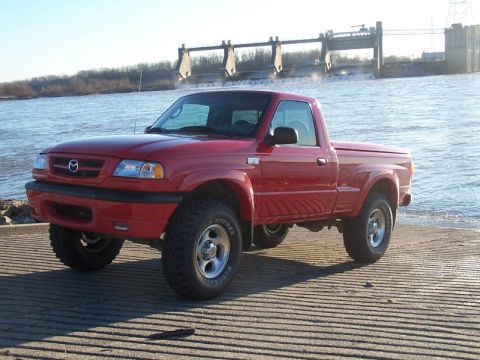 2001 Mazda B3000 - This red 2001 Mazda B3000 pickup truck is parked on a boat ramp with a dam in the background.