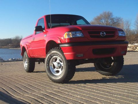2001 Mazda B3000 - This red 2001 Mazda B3000 pickup truck is parked on a ramp by the water.
