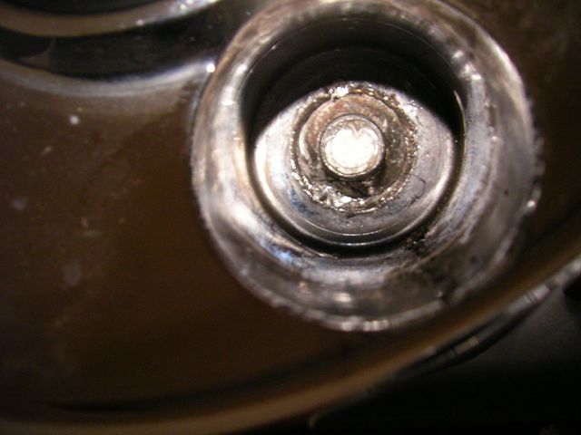 Spark plug well with a bolt and some debris