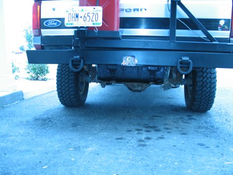 1995 Ford Bronco - The rear of a Ford truck is shown, a heavy-duty bumper, off-road tires, and a mounted gas can.