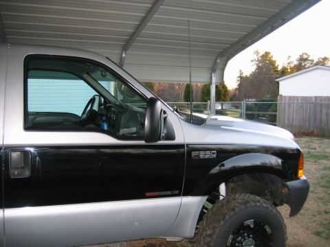 1992 Ford Mustang - Side view of a silver and black Ford F-350 Super Duty truck parked under a carport.
