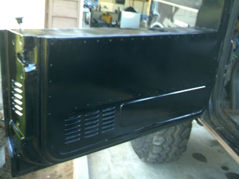 1989 Ford Bronco - Close-up of a black vehicle door panel, showing rivets and ventilation grilles.