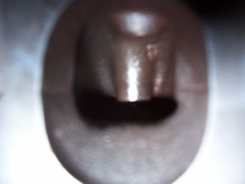 1979 Ford Bronco - A close-up view of an engine part, possibly a valve or a similar component, with a dark, metallic finish.