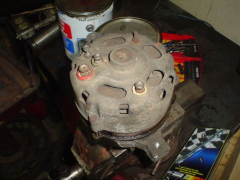 1967 Ford F-250 - Close-up view of an automotive alternator, held securely in a vise for inspection or repair.