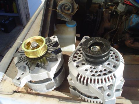 1967 Ford F-250 - Two alternators are compared, one with a gold pulley and fan, the other with a black pulley.