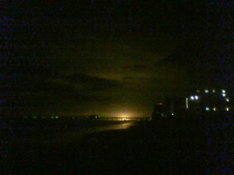 1989 Ford Bronco - Distant lights illuminate the horizon at night, with a building visible on the right side.