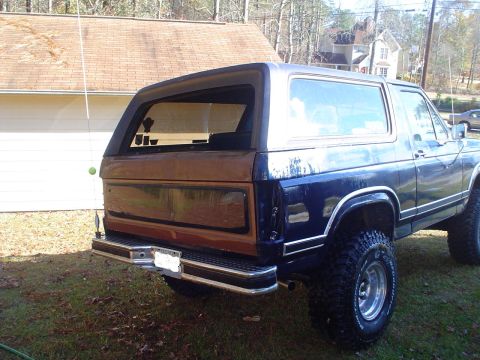 1984 Ford Bronco - Rear view of a 1984 Ford Bronco, woodgrain paneling on the tailgate and a chrome bumper.